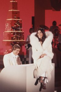 Carpenters-At-Christmas-opening-color-wide-Karen-sitting-on-piano-cropped-199x300.jpg